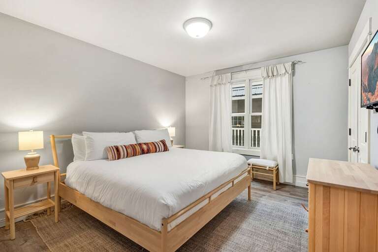 Guest room 2 features a King Bed and flat screen TV with a shared guest bathroom located just across the hall.