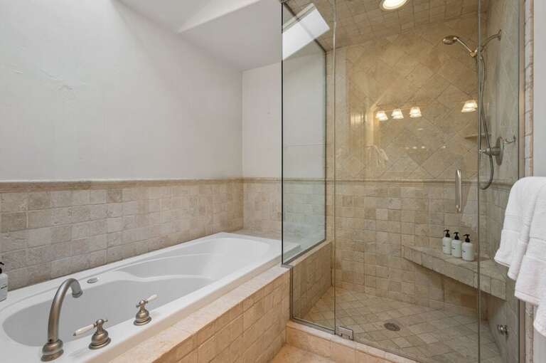 Large soaking tub with tiled step in shower, double vanity and water closet is all you need for a relaxing evening after many adventures.