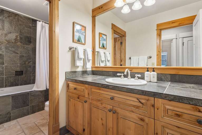 The Shared guest bathroom on the entry level  features soaking tub, single vanity and water closet.