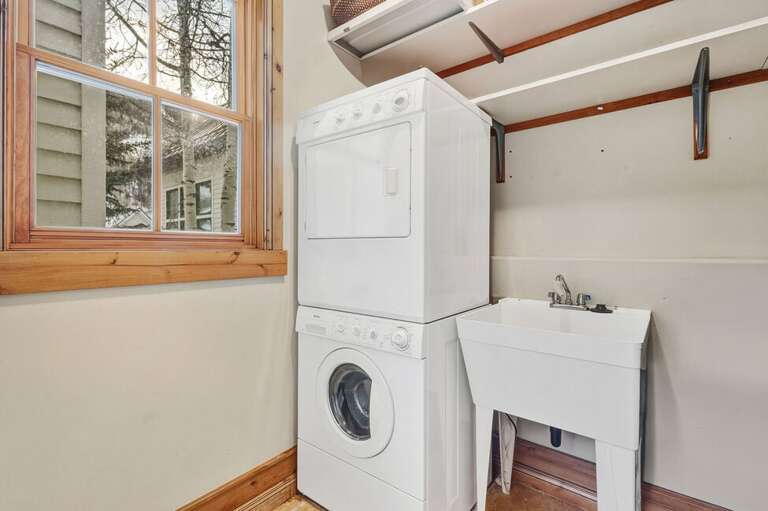 Utility room off the kitchen offers sink and stackable washer and dryer.