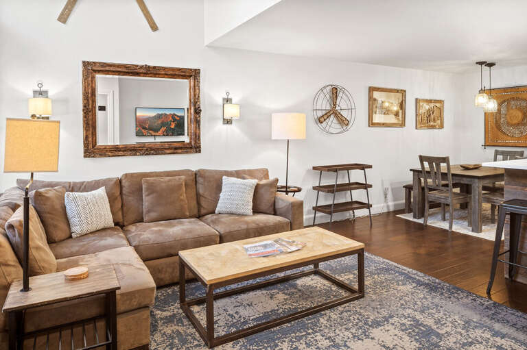Open-concept living and kitchen area with modern stainless steel appliances and a dining table for 6, perfect for families to cook, dine, and relax together.