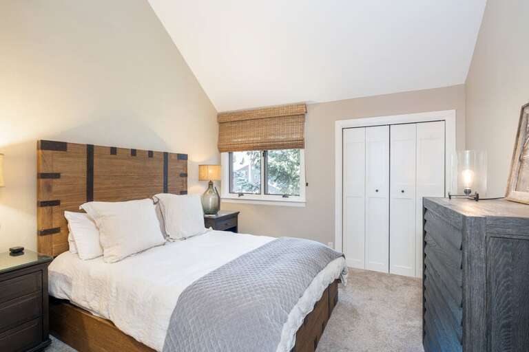 The main-level guest room offers a comfortable queen-size bed, perfect for a restful night's sleep.