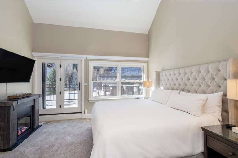 The primary suite is located on the second level of the condo and features an ensuite bathroom, King bed, electric fireplace and access to the outdoor shared deck area.