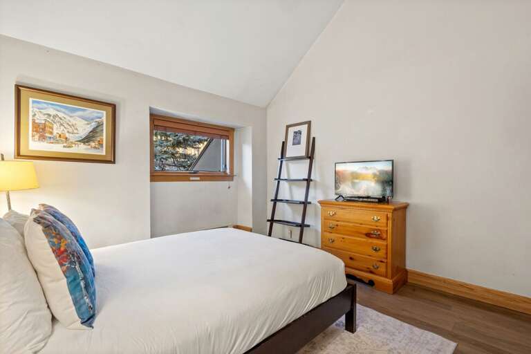 The guest room, located off the dining area, features a queen bed, large closet, vaulted ceilings and natural light.