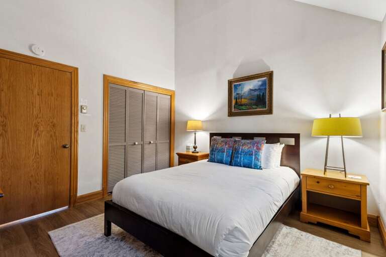 The guest room, located off the dining area, features a queen bed, large closet, vaulted ceilings and natural light.