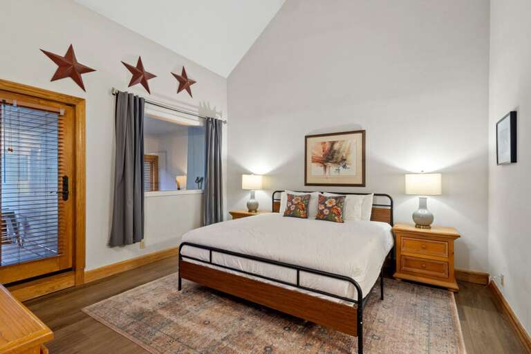 Primary Suite features access to the private deck, ensuite bathroom with step in shower/tub, large closet, king bed and vaulted ceilings.