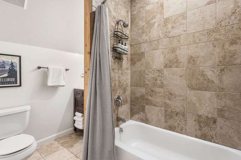 The bathroom features a single sink vanity, shower/bathtub combo and is located on the top level with the Primary Bedroom.