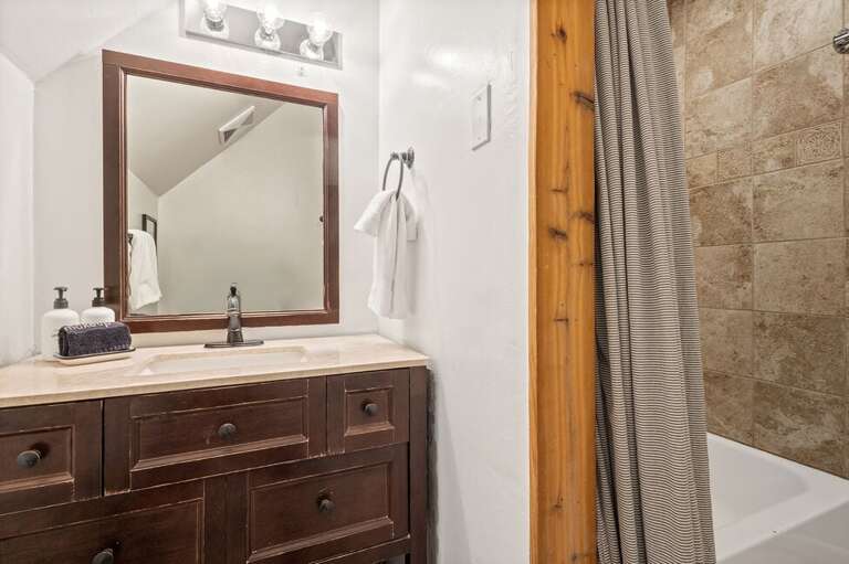 The bathroom features a single sink vanity, shower/bathtub combo and is located on the top level with the Primary Bedroom.