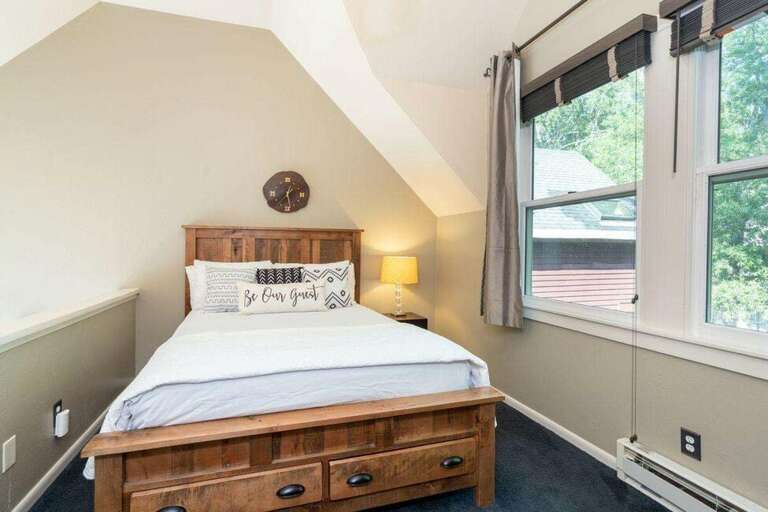 The queen bedroom is open to the living space below and overlooks the creek.