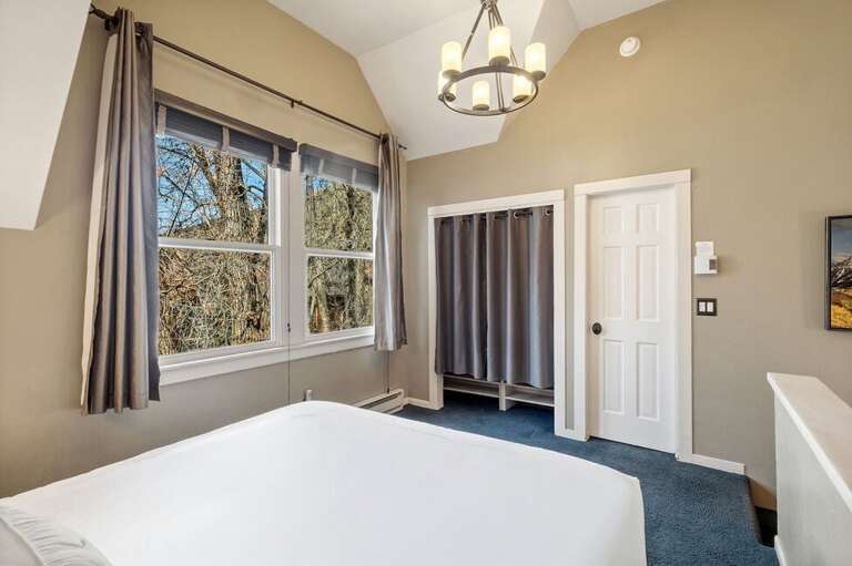 A relaxed lofted king suite with its own bathroom, offering beautiful views outside and the steady, calming sound of the creek below.