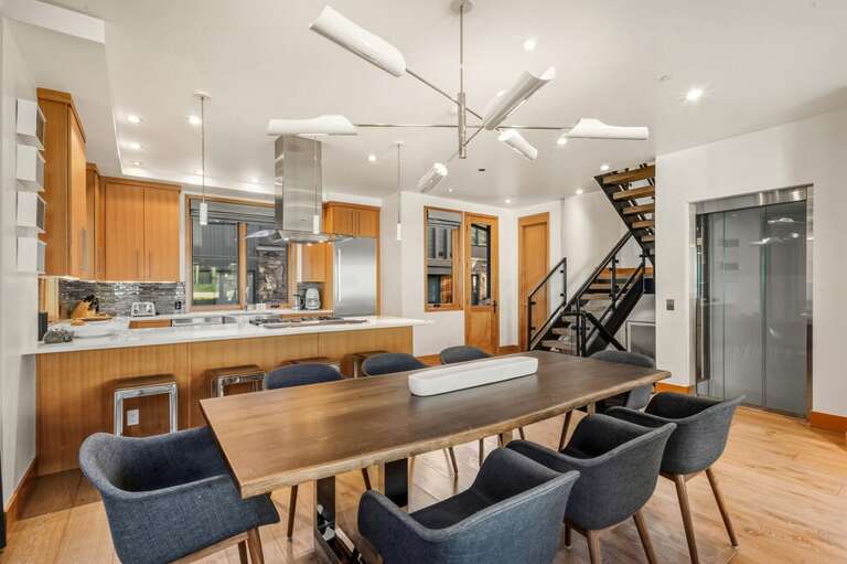 Elegant open-concept living, dining, and kitchen space with ample table seating for eight, ideal for entertaining.