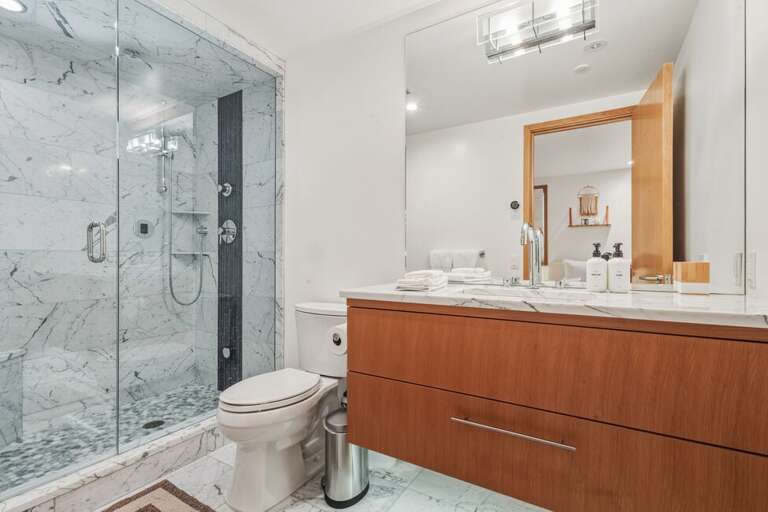 The ensuite bathroom to the pink guest room features step in shower and single vanity.