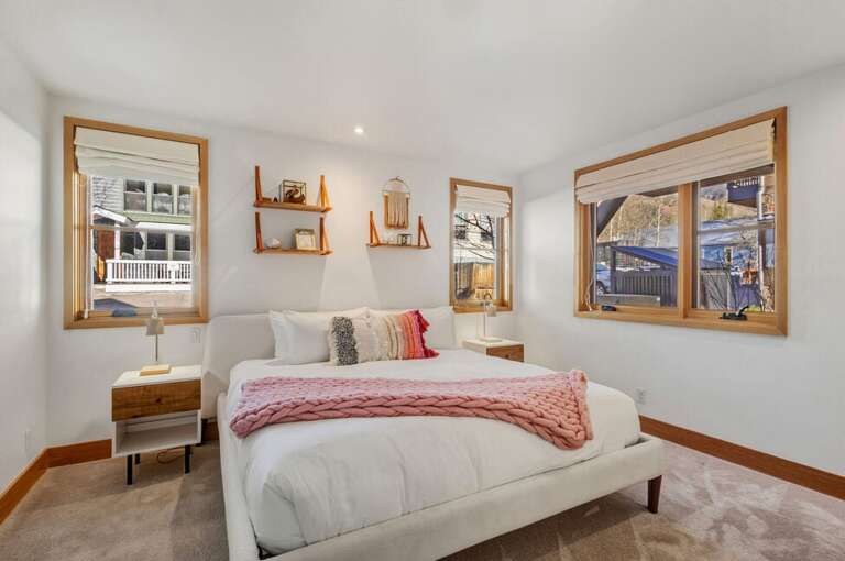 The Pink Guest Room on the entry level offers a king bed, en suite bathroom, and a cozy, warm ambiance perfect for relaxing.