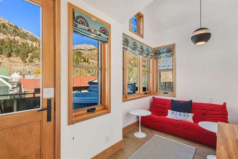 A serene nook adjoining the primary suite is ideal for unwinding, catching a film, or enjoying solitude, while providing access to the private hot tub.