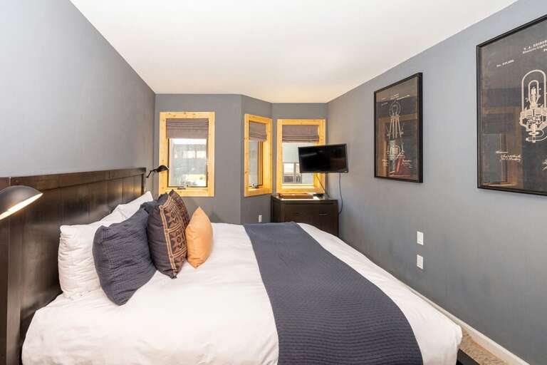 King guest bedroom downstairs features beautiful light through the windows.