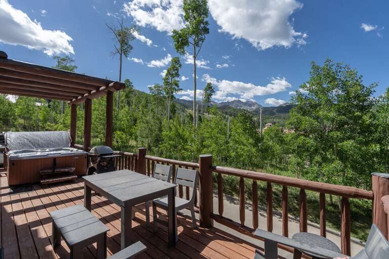 The large deck includes outdoor dining furniture and a private hot tub. The large deck includes outdoor dining furniture and a private hot tub.