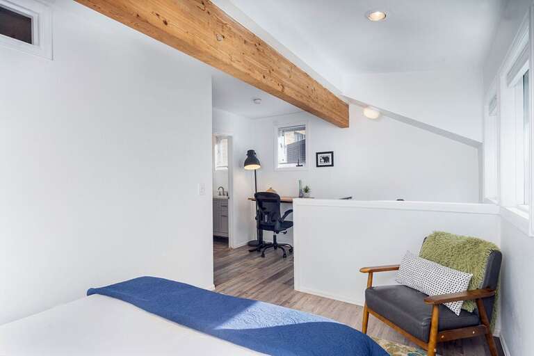 The loft space at the top of the spiral stairs features a queen bed. A privacy screen lets you close off the space a little more.