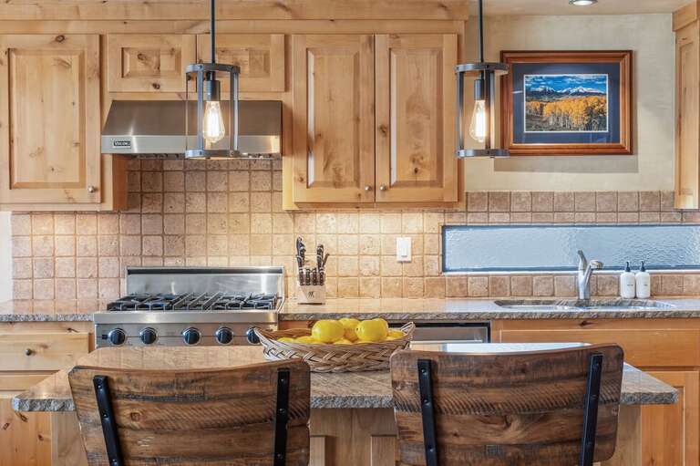 A chef-friendly kitchen with a large island, generous counter space, and seating for two—perfect for cooking and gathering.