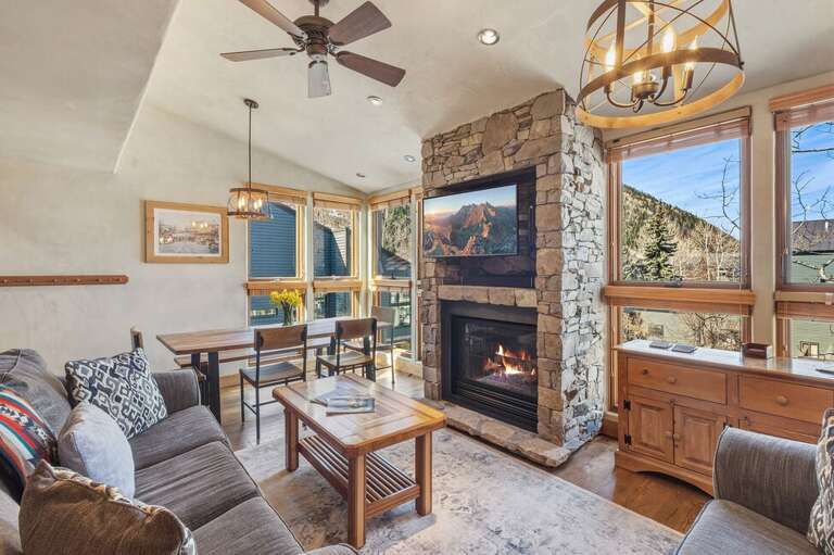 Floor-to-ceiling windows fill the space with natural light, making the living and dining area feel open and airy.