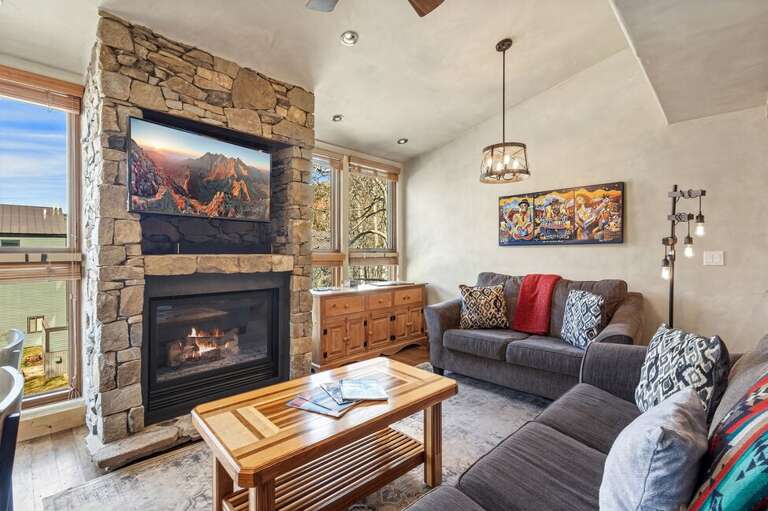 Relax by the fireplace after a day on the mountain in this cozy, comfortable living space.
