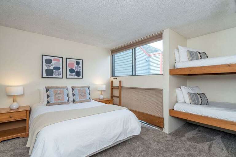 Third level bedroom features a queen bed and a set of bunk beds with an en suite bathroom.