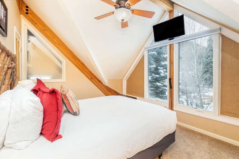 On the second level this queen bedroom faces beautiful views of the mountains.
