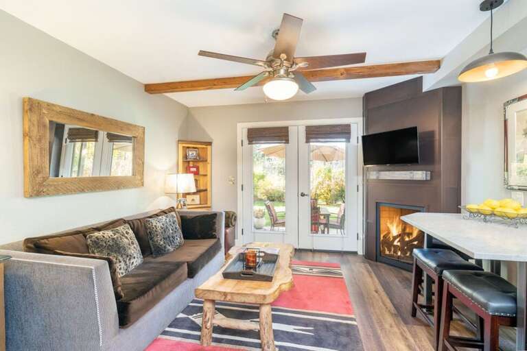 The living area features a pull-out couch, fireplace and bar-top dining area.