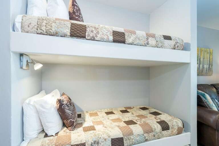 The bunk beds are in between the queen bedroom and the kitchen/living area. Please note, these are small bunk beds so really only good for kids! The bunk beds are in between the queen bedroom and the kitchen/living area. Please note, these are small bunk beds so really only good for kids!