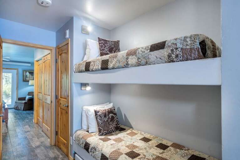 The bunk beds are in between the queen bedroom and the kitchen/living area. Please note, these are small bunk beds twins, so really only good for kids! The bunk beds are in between the queen bedroom and the kitchen/living area. Please note, these are small bunk beds twins, so really only good for kids!