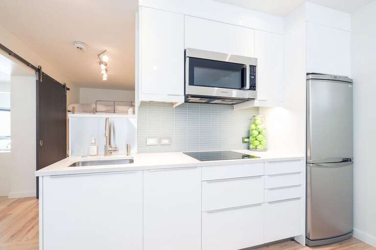 The kitchen has an induction cooktop (please note, no oven), full sized fridge & microwave.