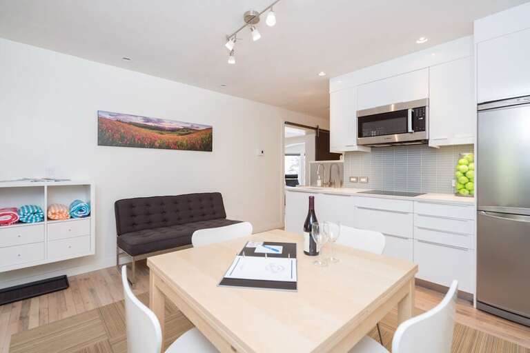 The kitchen has a small dining table for 4 people and a small loveseat sofa.