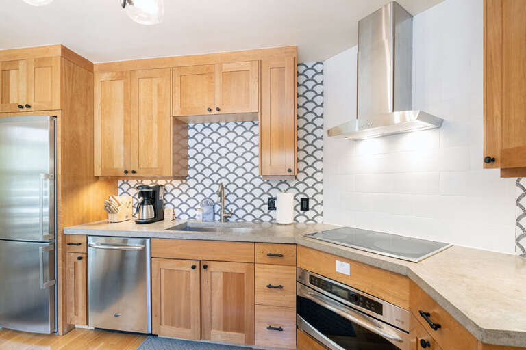 The kitchen features custom cabinetry, stainless appliances & a concrete countertop. It is also fully equipped with all of the basics supplies for your stay! The kitchen features custom cabinetry, stainless appliances & a concrete countertop. It is also fully equipped with all of the basics supplies for your stay!