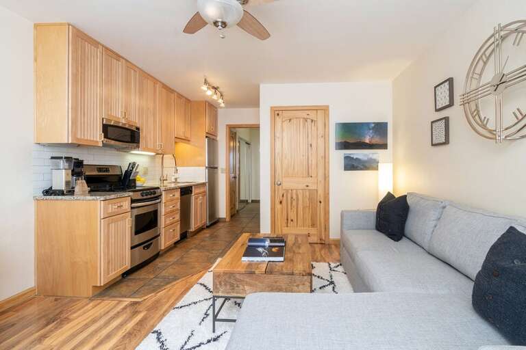 The living room has a new sofa, coffee table, and mid-century dining table for 4.