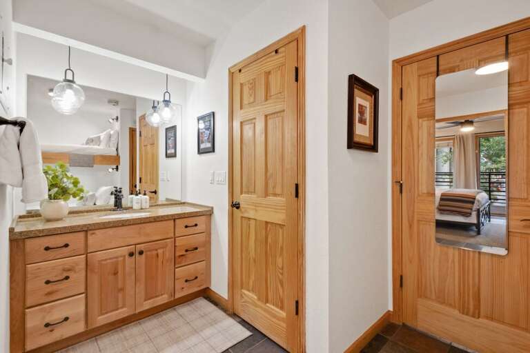 The bathroom features a spacious single vanity, with the shower and toilet tucked away in a separate private room for added privacy and convenience.