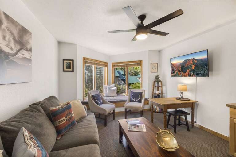 The living area offers a cozy lounge space with stunning views of San Miguel and the ski mountain, perfect for relaxing after a day outdoors.