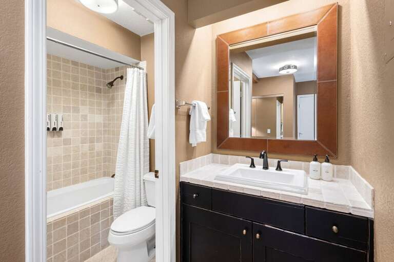 The toilet and shower are separated by a door for privacy.