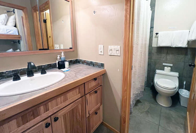 The bathroom is next to the bunks and has a combined shower and tub.