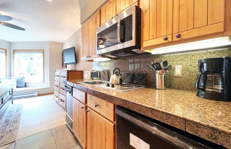 The condo has a kitchenette with a mini fridge, cooktop, microwave, dishwasher and coffee maker.