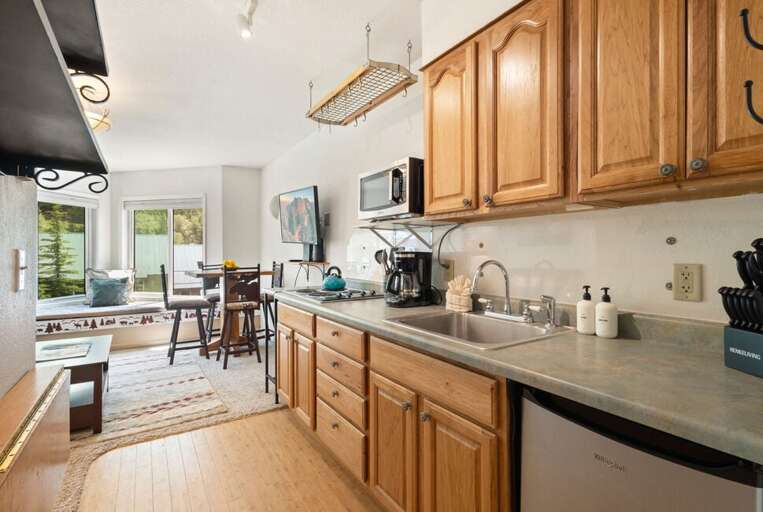 Galley kitchen with stove top and mini fridge