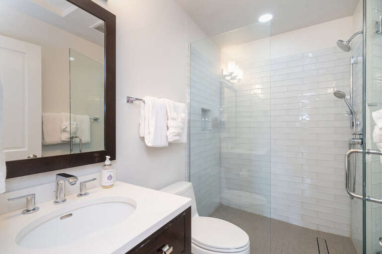 This beautifully remodeled guest bathroom features a tiled showe. Shared by both guest rooms on the main level.