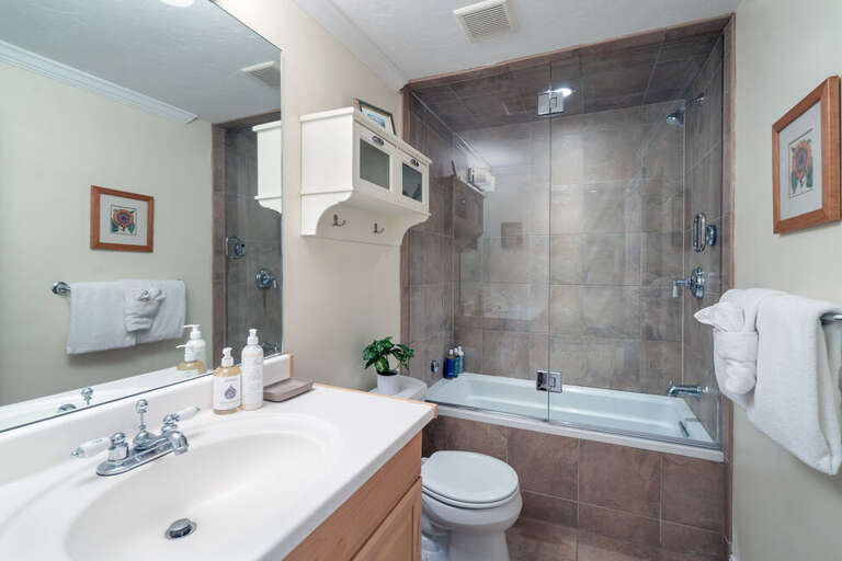 This shared bathroom features a tub/shower combo with single vanity and plenty of space. This shared bathroom features a tub/shower combo with single vanity and plenty of space.
