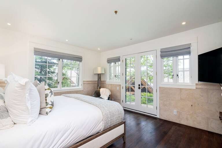 This bottom level Primary Bedroom offers a private outdoor seating area to enjoy the sounds of the Mountains.