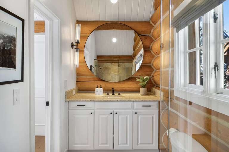 This guest room features an ensuite bathroom with ample vanity space, combining comfort and modern style for your stay.