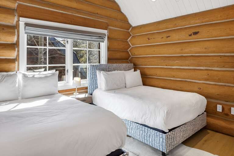 Spacious second-floor Guest Room 2 with two double beds and an elegant ensuite bathroom for ultimate convenience.