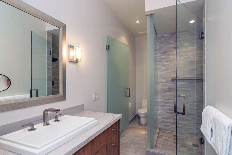The first level en suite bathroom features a beautiful walk-in shower with single vanity and private water closet. The first level en suite bathroom features a beautiful walk-in shower with single vanity and private water closet.