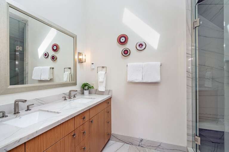 The primary bathroom features a double vanity and marble step in shower. The primary bathroom features a double vanity and marble step in shower.