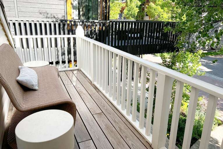 Deck off the primary bedroom overlooks the front yard and residential area.