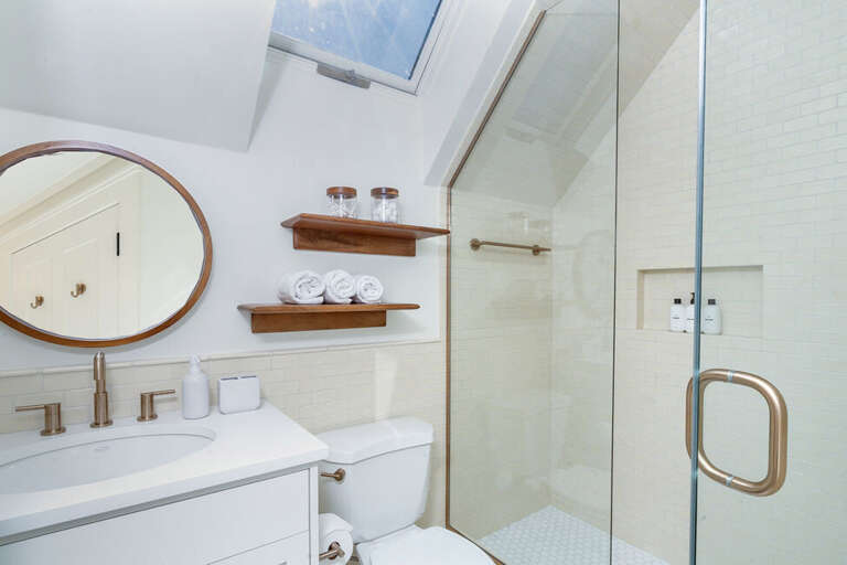 Third floor shared bathroom offers lots of natural light, a beautifully tiled walk-in shower and large vanity.