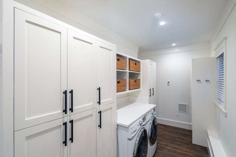The laundry/pantry room, located off the spacious mudroom on the main level and adjacent to the kitchen, offers plenty of storage space for food and supplies.