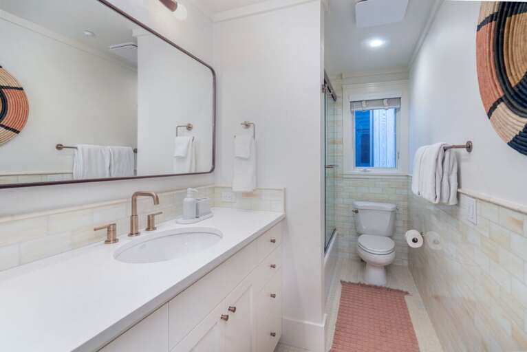 The shared second-floor bathroom offers a shower/tub combination, stylish single vanity, and a bright, space.